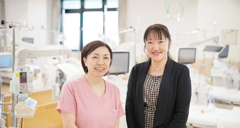 ピンクのスクラブを着用した女性スタッフと、透析事業本部副本部長熊澤ひとみが、並んで笑顔を見せている様子