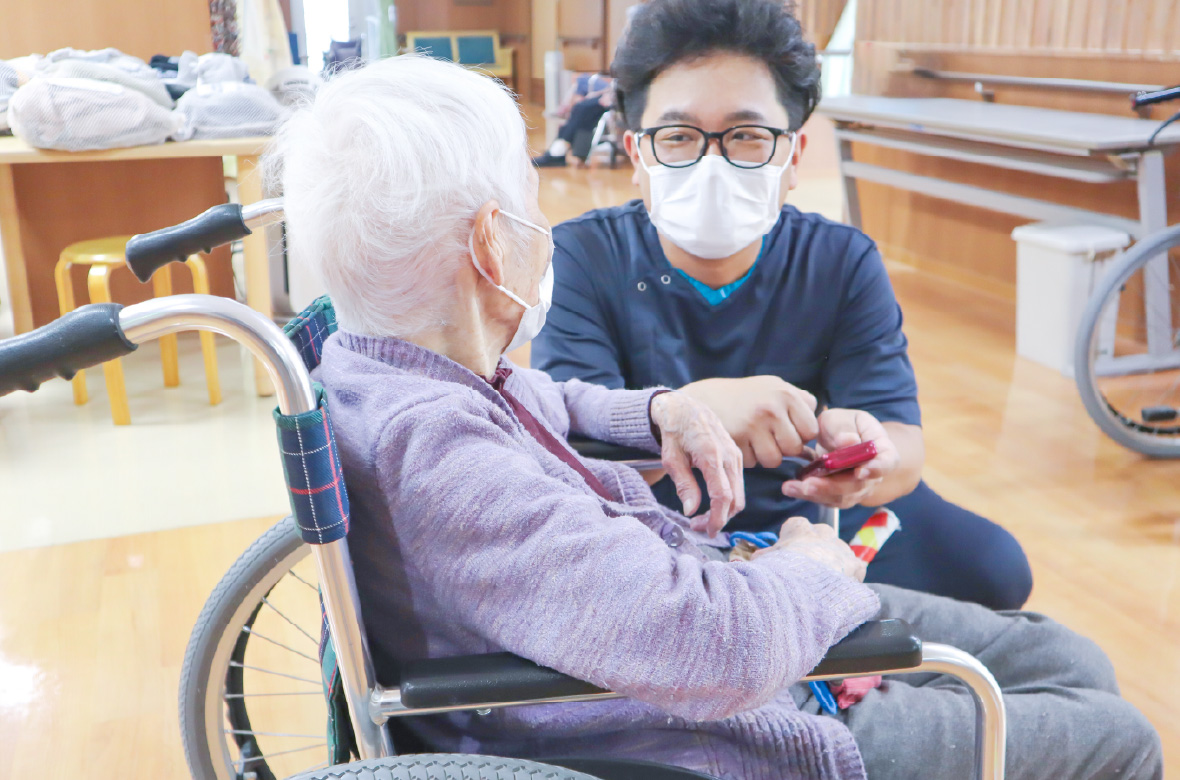 車椅子の利用者の方に優しく声をかける男性スタッフの様子